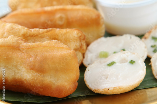 Fried patongko and Kanom krok or coconut-rice pancake on golden plate.