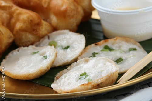 Fried patongko and Kanom krok or coconut-rice pancake on golden plate.