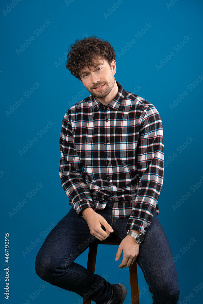 handsome man with handsome dreamy look posing at camera on blue background handsome man with handsome dreamy look posing at camera on blue background