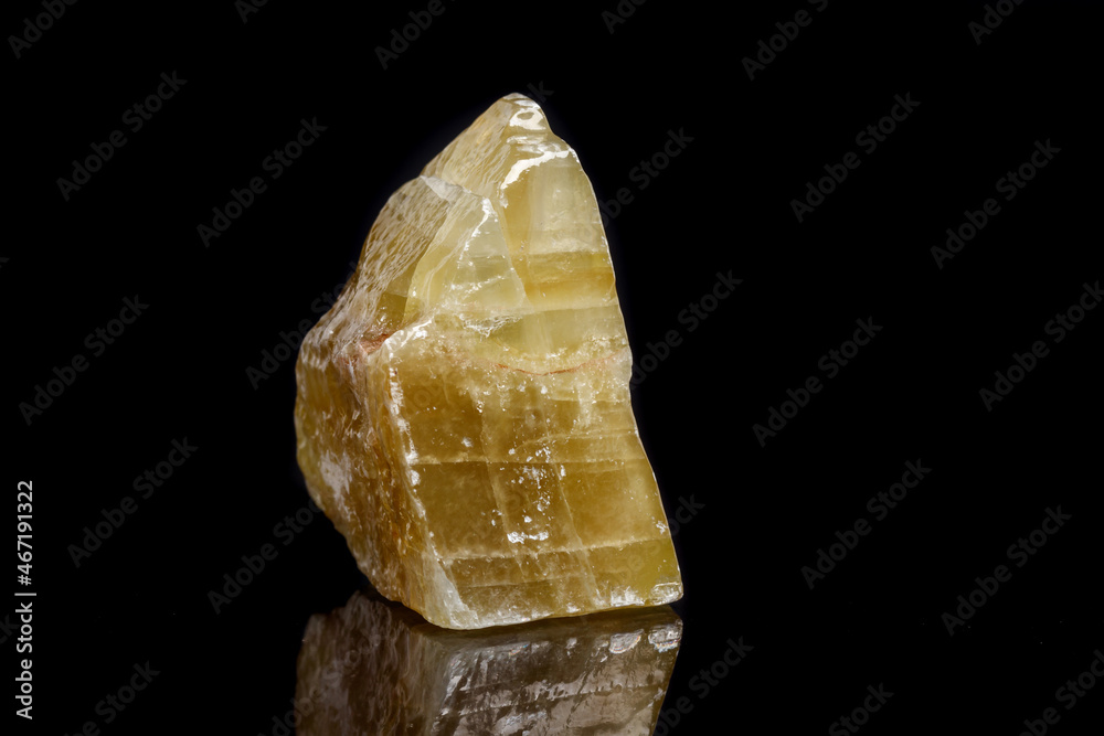 Macro mineral stone yellow Calcite on a black background