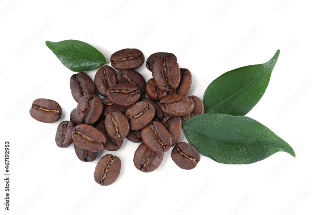 Fototapeta premium Pile of roasted coffee beans with fresh leaves on white background, top view