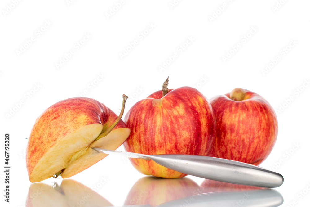 One half and two whole organic juicy apples with a metal knife, close-up, isolated on white. One half and two whole organic juicy apples with a metal knife, close-up, isolated on white.