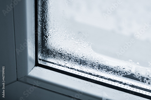 Condensation on the glass. Defective plastic window. Sweating windows in the house. Drops of water on the glass. Selective focus.