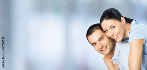 Happy amazed smiling couple. Portrait of standing close embracing  piggyback pose models in love concept  indoors. Brunette man and woman together. Copy space area.
