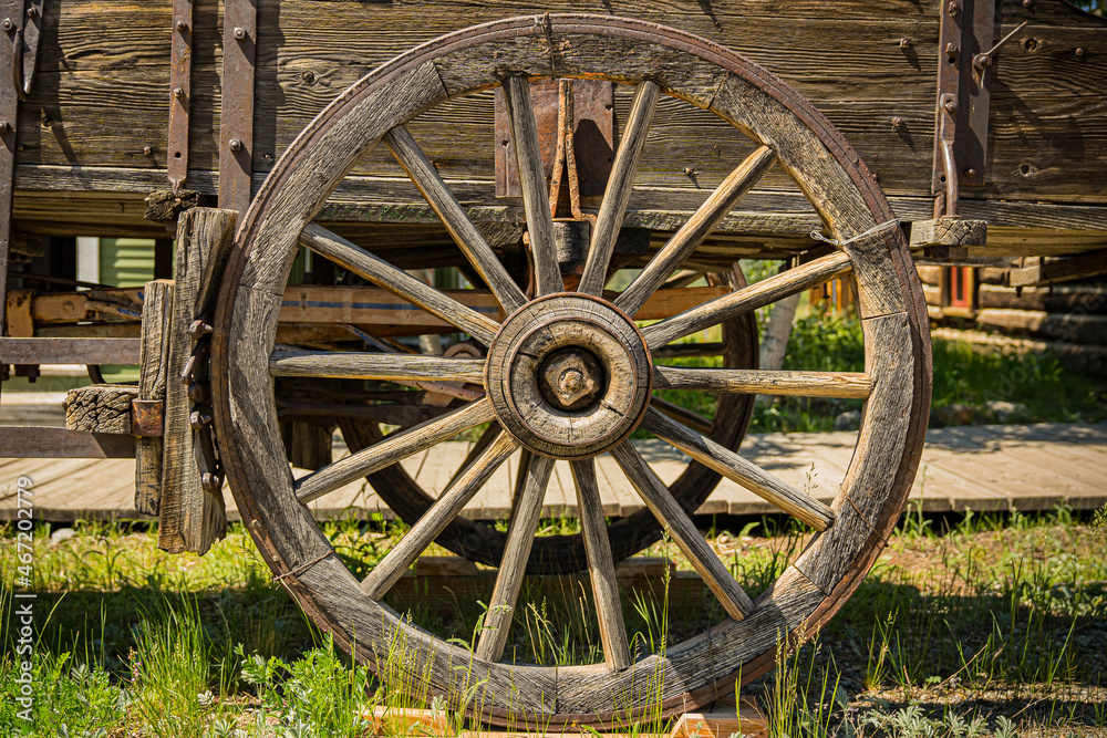 Old wooden wagon wheel on a cart