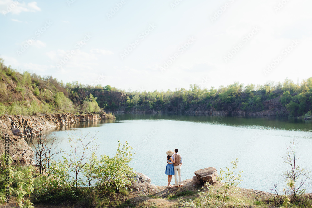 a young couple a guy and a girl are walking near a mountain lake surrounded a young couple a guy and a girl are walking near a mountain lake surrounded