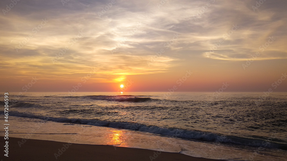 Beautiful autumn sunset over the Atlantic ocean in Quiaios Beach, Portugal with dramatic cloudy sky. Nature photography in warm tones taken at dusk