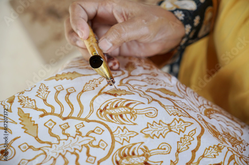 The process of making batik. Batik is a handmade traditional art from Indonesia. Produced by technique of wax-resist dyeing applied to fabric. photo