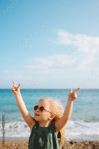 Canvas Print Child girl walking on beach sea outdoor baby in sunglasses 3 years old kid raise