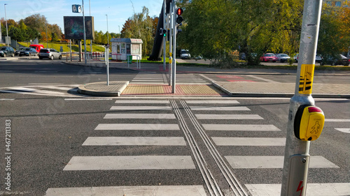 Prague, Czech Republic - October 24, 2021: Empty pedestrian crossing on a busy crossroad with red color being currently displayed on the traffic light. The yellow button says 