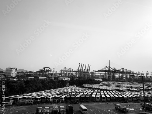 Grayscale photo of busses parked in parking lot near seaport in Hong Kong photo