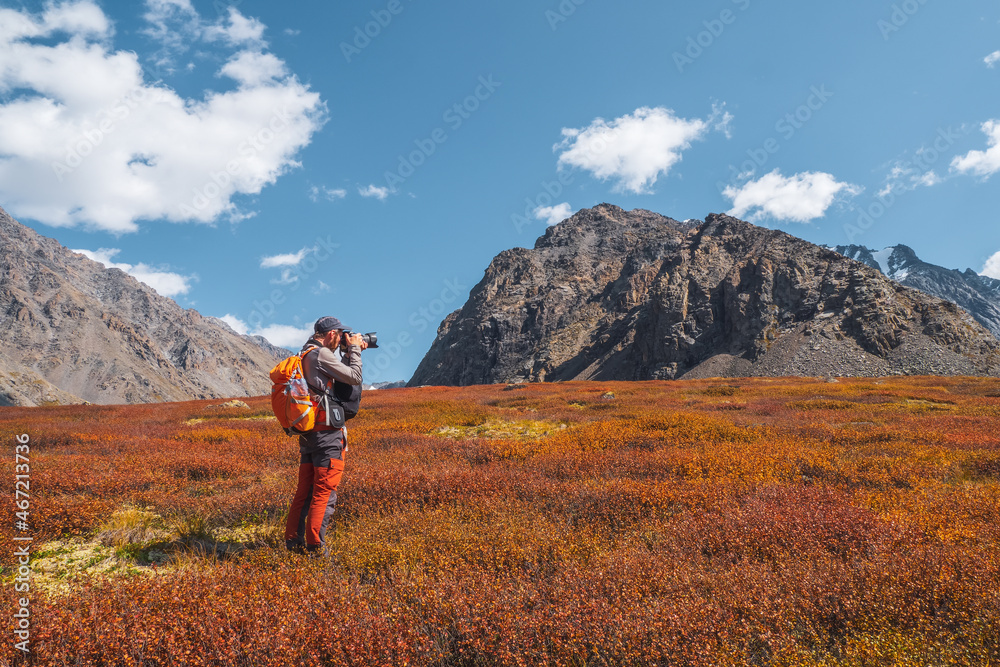 Travel photographer take a picture of beautiful view in high autumn mountains. Travel freelancer blogger lifestyle, concept adventure voyage outdoor.