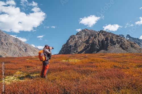 Travel photographer take a picture of beautiful view in high autumn mountains. Travel freelancer blogger lifestyle, concept adventure voyage outdoor.