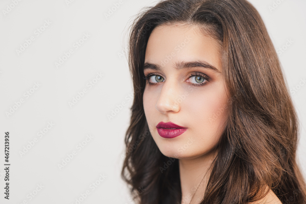 Young girl with bright makeup and hair styling. Strict look straight into the camera. Natural makeup. Bright green eyes. Young girl with bright makeup and hair styling. Strict look straight into the camera. Natural makeup. Bright green eyes.