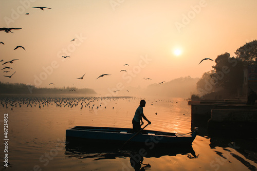 Man on paddling boat during golden hour photo
