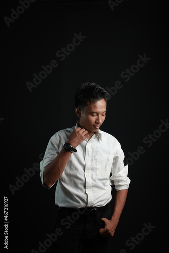 Portrait of young man standing against dark background photo