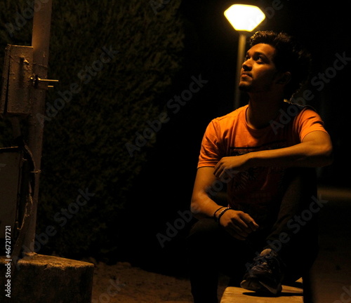 Sitting man wearing brown shirt looking up photo