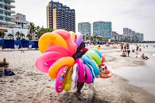 Street seller holding inflatable rings at the beach in Cartagena, Bolivar,  Colombia photo