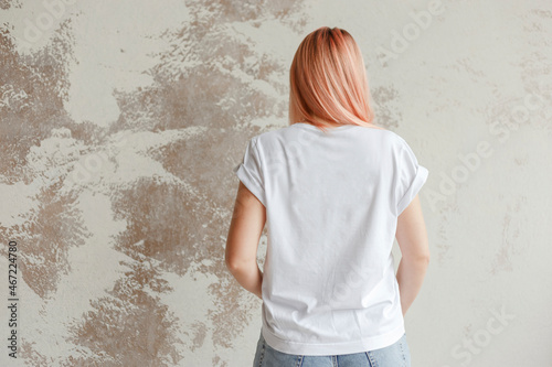 Obraz na płótnie Young girl wearing blank white t-shirt. Back view. Concrete wall background w salonie