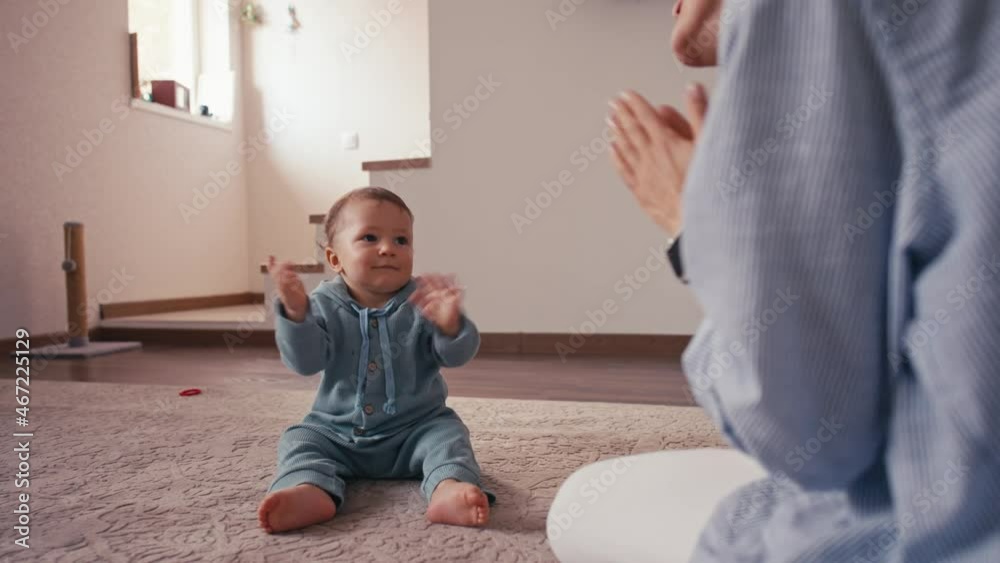 Happy caucasian family mother and cute little boy son learning how to clap hands having fun enjoying sweet moments together. Happy caucasian family mother and cute little boy son learning how to clap hands having fun enjoying sweet moments together.