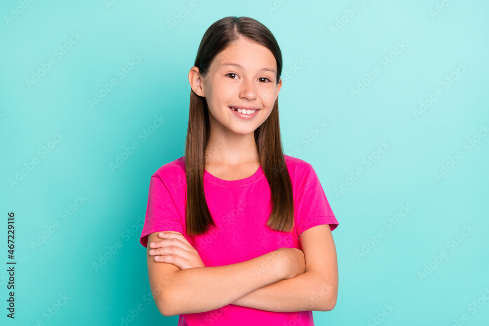 Photo of confident happy young small girl hold hands crossed good mood smile isolated on teal color background Photo of confident happy young small girl hold hands crossed good mood smile isolated on teal color background