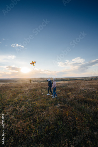 A happy couple flies a kite and spends time together in the fresh air. Happy relationship and family vacation.