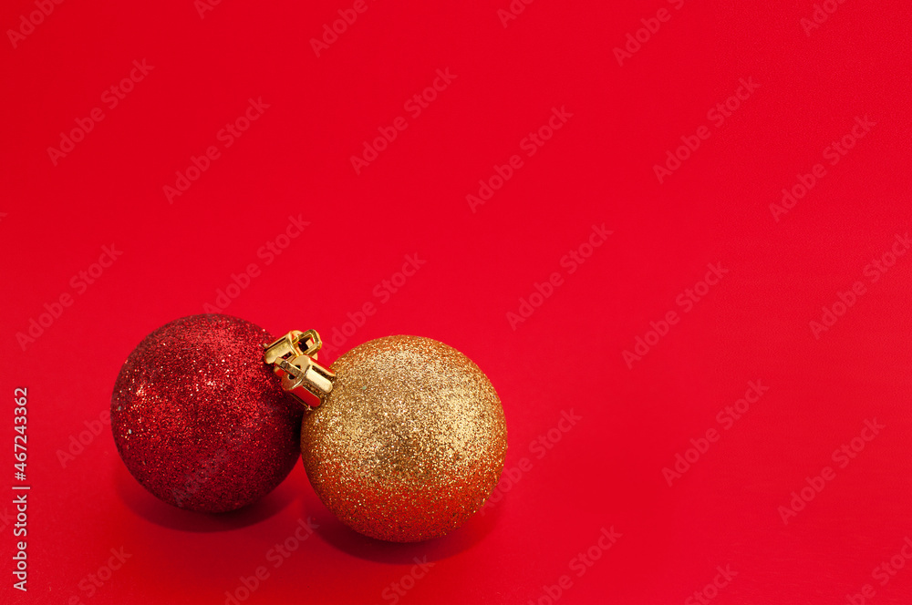 two shiny Christmas balls of red and gold colors on a red background two shiny Christmas balls of red and gold colors on a red background