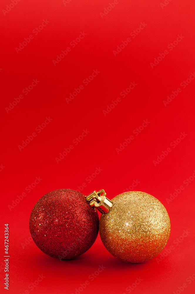two shiny Christmas balls of red and gold colors on a red background two shiny Christmas balls of red and gold colors on a red background