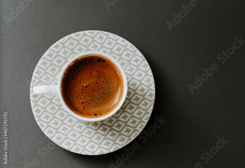 Turkish coffee in a white patterned cup with black background