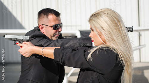 Professional female and male security spy agents posing with guns © guruXOX
