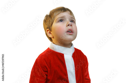 A boy in a Santa Claus costume looks away