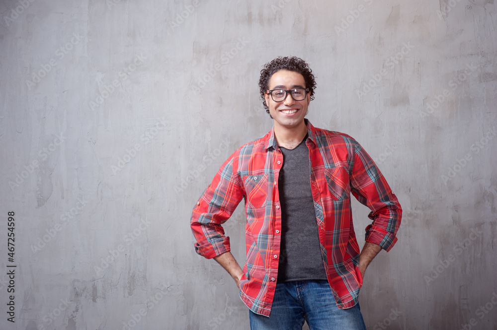 young man in casual shirt holding hands in pockets