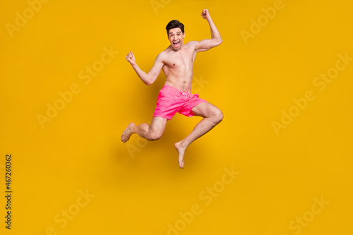 Full length body size view of attractive cheery lucky guy jumping having fun isolated over bright yellow color background