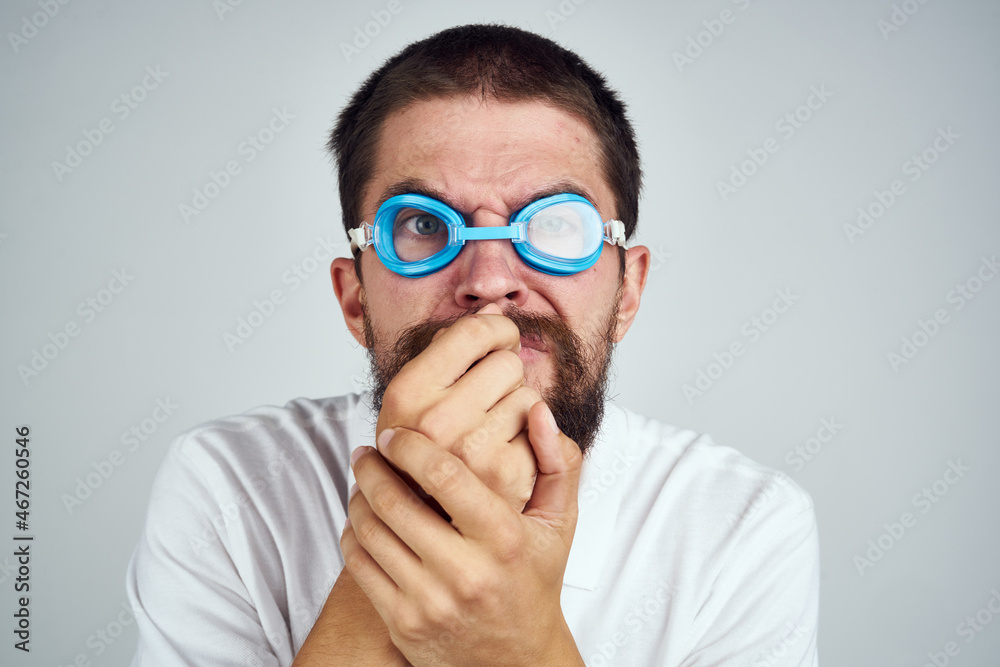 man in goggles for swimming in a white shirt emotions close-up man in goggles for swimming in a white shirt emotions close-up