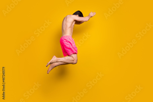 Full body profile side photo of young man swim ocean travel snorkeling isolated over yellow color background