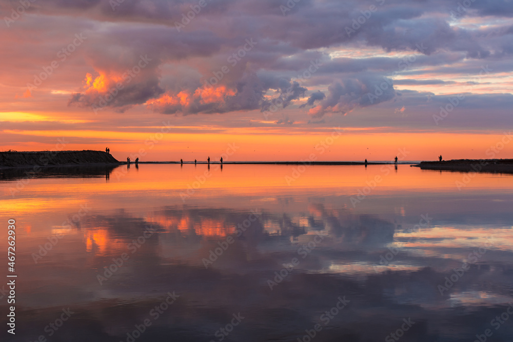 Reflection of clouds and sky in the calm river, sunset in the calm lake with silhouette of boat and fishermen, sandy coast in the bank of big river, Fishing by traditional methods in beautiful lake. Reflection of clouds and sky in the calm river, sunset in the calm lake with silhouette of boat and fishermen, sandy coast in the bank of big river, Fishing by traditional methods in beautiful lake.