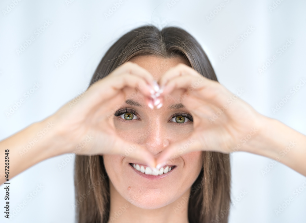 Perfect vision after eye surgery or ophthalmic surgery. Young woman with perfect vision makes heart shape with hands. Healthy eyes. Ophthalmology concept. Perfect vision after eye surgery or ophthalmic surgery. Young woman with perfect vision makes heart shape with hands. Healthy eyes. Ophthalmology concept.