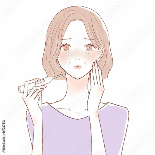 体温計で熱を測る中年女性