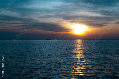 The sunset shines brightly on the sea, the dark black sky is beautiful.