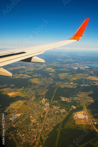 Classic image through aircraft window onto wing. Flight view over Russia