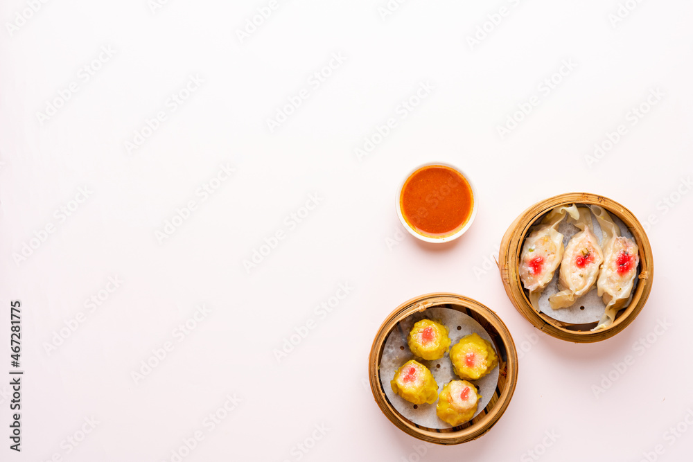 Top View of Assorted Chinese Dimsum in bamboo basket. Dimsum is a large range of small dishes that Cantonese people traditionally enjoy in restaurants for breakfast and lunch.