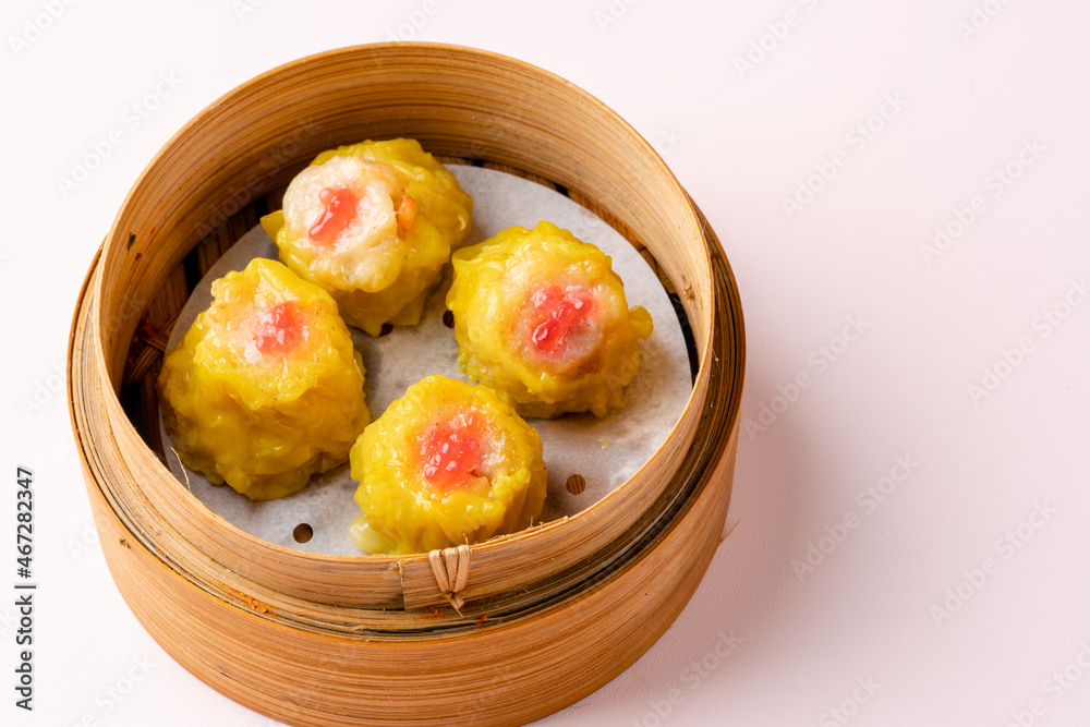 Top View of Assorted Chinese Dimsum in bamboo basket. Dimsum is a large range of small dishes that Cantonese people traditionally enjoy in restaurants for breakfast and lunch. Top View of Assorted Chinese Dimsum in bamboo basket. Dimsum is a large range of small dishes that Cantonese people traditionally enjoy in restaurants for breakfast and lunch.