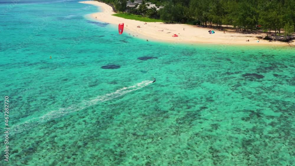 Kitesurfing Le Morne, Mauritius. Drone view flying backwards in front of kite surfer. Kite surfer surfing crystal clear water, perfect waves. Aerial view Kitesurfing Le Morne, Mauritius. Drone view flying backwards in front of kite surfer. Kite surfer surfing crystal clear water, perfect waves. Aerial view