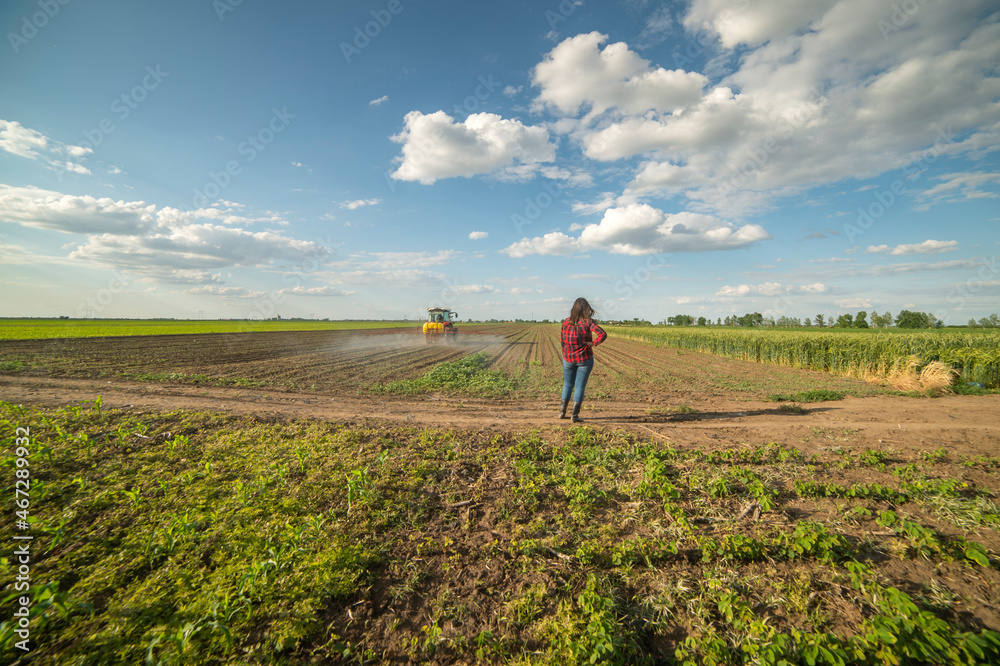 Young farmer woman standing on farmland Young farmer woman standing on farmland