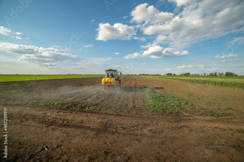 Tractor spraying soil in field