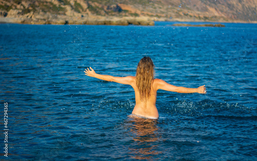 the girl enters the sea water photo