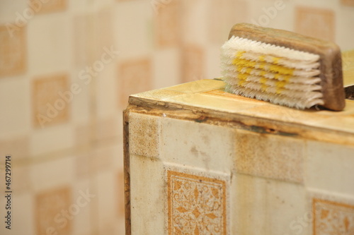 dirty bathroom end wall and wooden brush