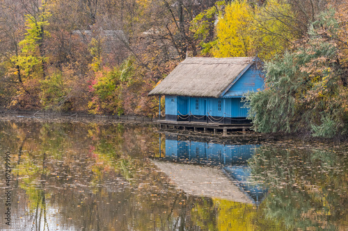 An Old Wooden Building Surrounded by Colorful Trees is Beautifully Reflected on the Lake Surface on a Cloudy Autumn Day