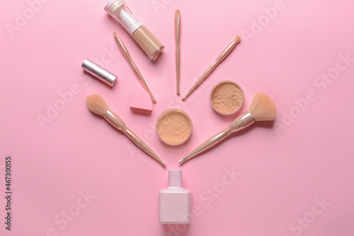 Set of professional makeup brushes with decorative cosmetics on color background