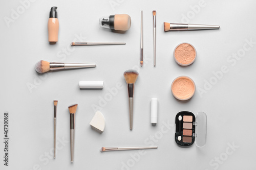 Fototapeta Naklejka Na Ścianę i Meble -  Set of professional makeup brushes with decorative cosmetics on light background
